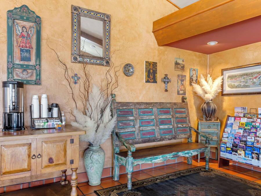 A cozy lobby with a wooden bench, a coffee station, a bulletin board, and decorative wall art.