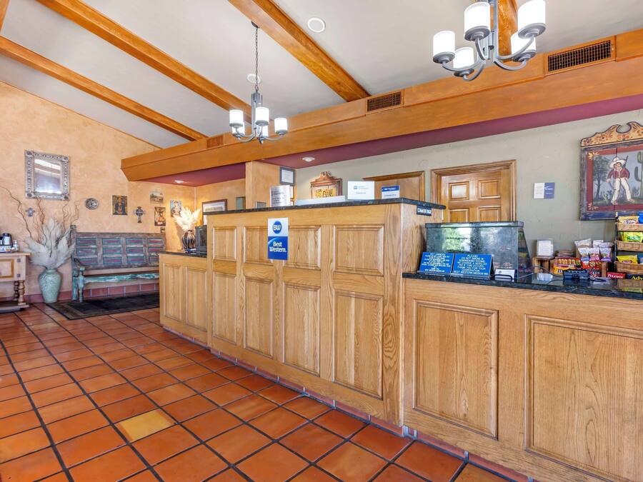 A reception area with wooden paneling, a tiled floor, and a chandelier.