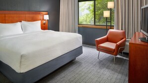A hotel room with a large bed, a desk, a chair, a TV, and a window with curtains. - Courtyard by Marriott Nashville Brentwood (Brentwood)