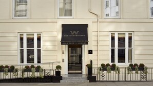 A hotel entrance with a sign reading "The Westbourne Hyde Park, London".