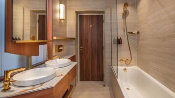 Une salle de bain moderne avec deux lavabos, un grand miroir et une baignoire.