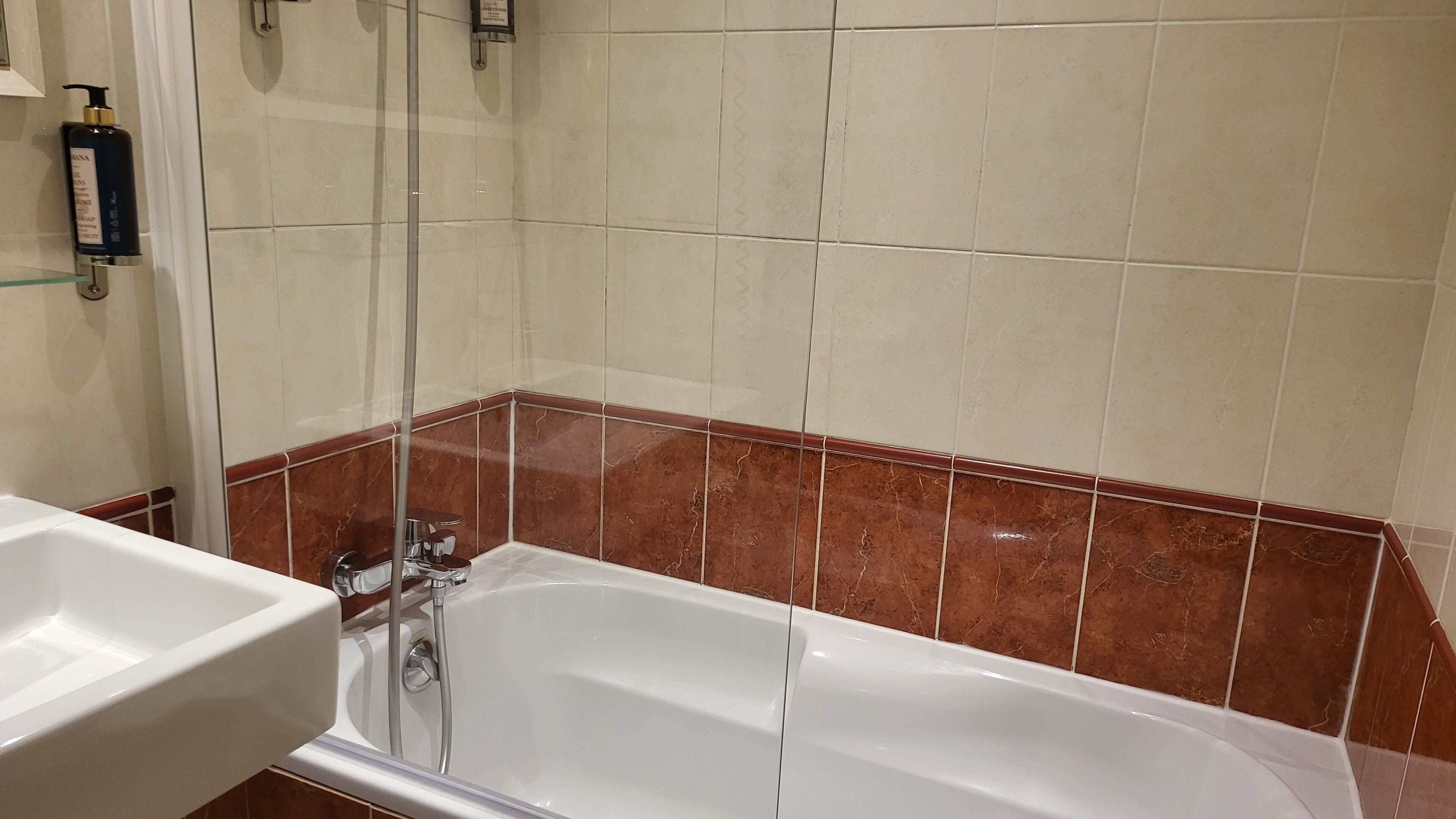 A bathroom with a bathtub, a shower, and a sink.