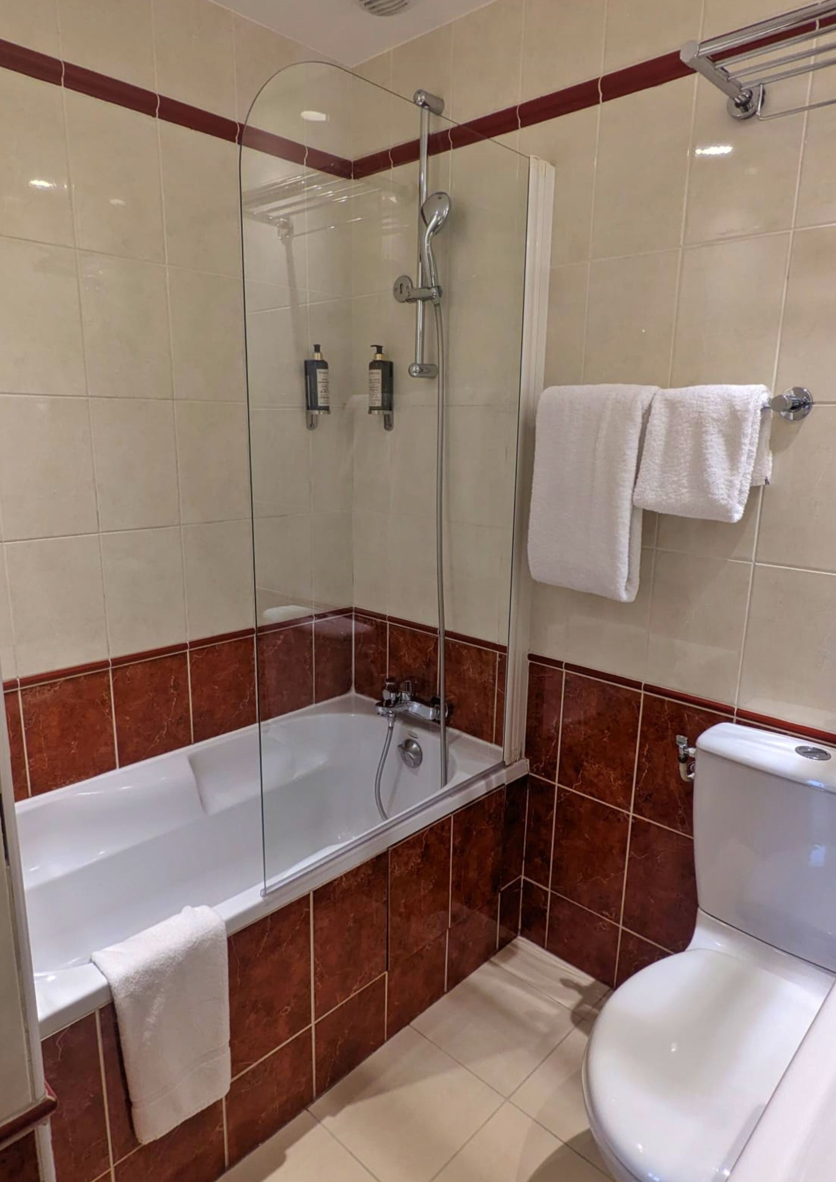 Un bagno con doccia vetrata, una vasca da bagno bianca e un water.