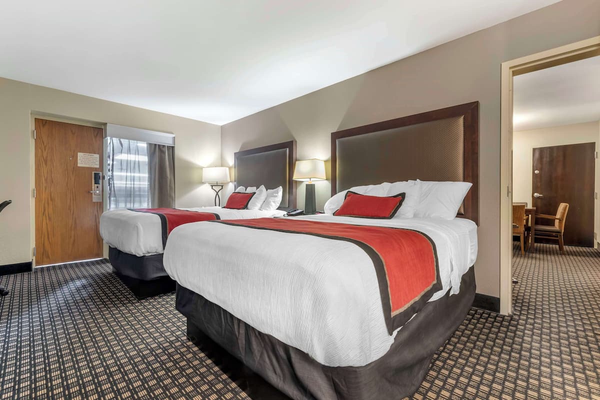 Ein Hotelzimmer mit zwei Betten, einem Schreibtisch und einem Stuhl.