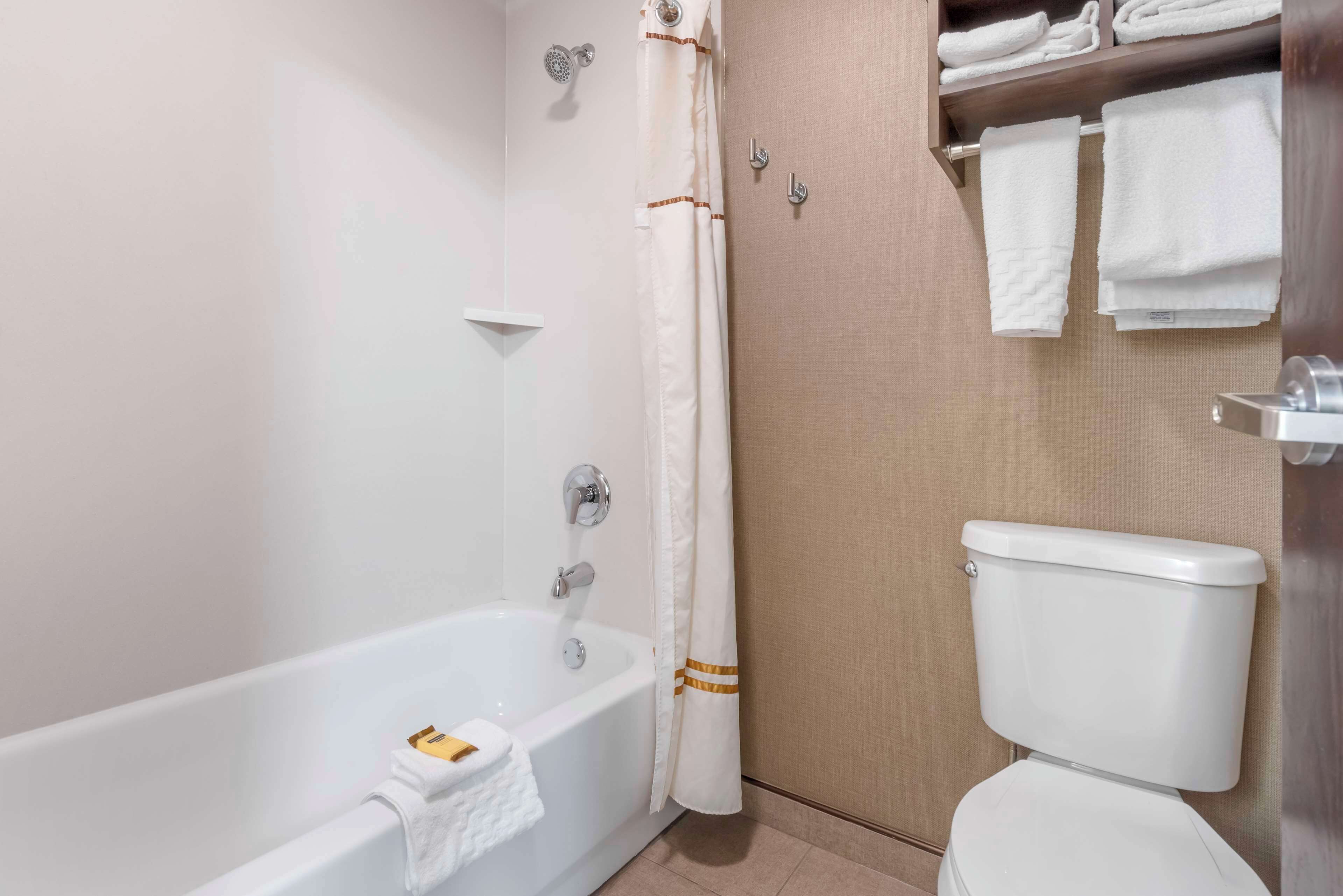 A bathroom with a bathtub, toilet, and towel rack.