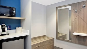 A modern bathroom with a built-in microwave, coffee machine, and a large mirror.