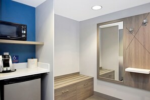 Un bagno moderno dotato di forno a microonde, macchina del caffè e un ampio specchio.