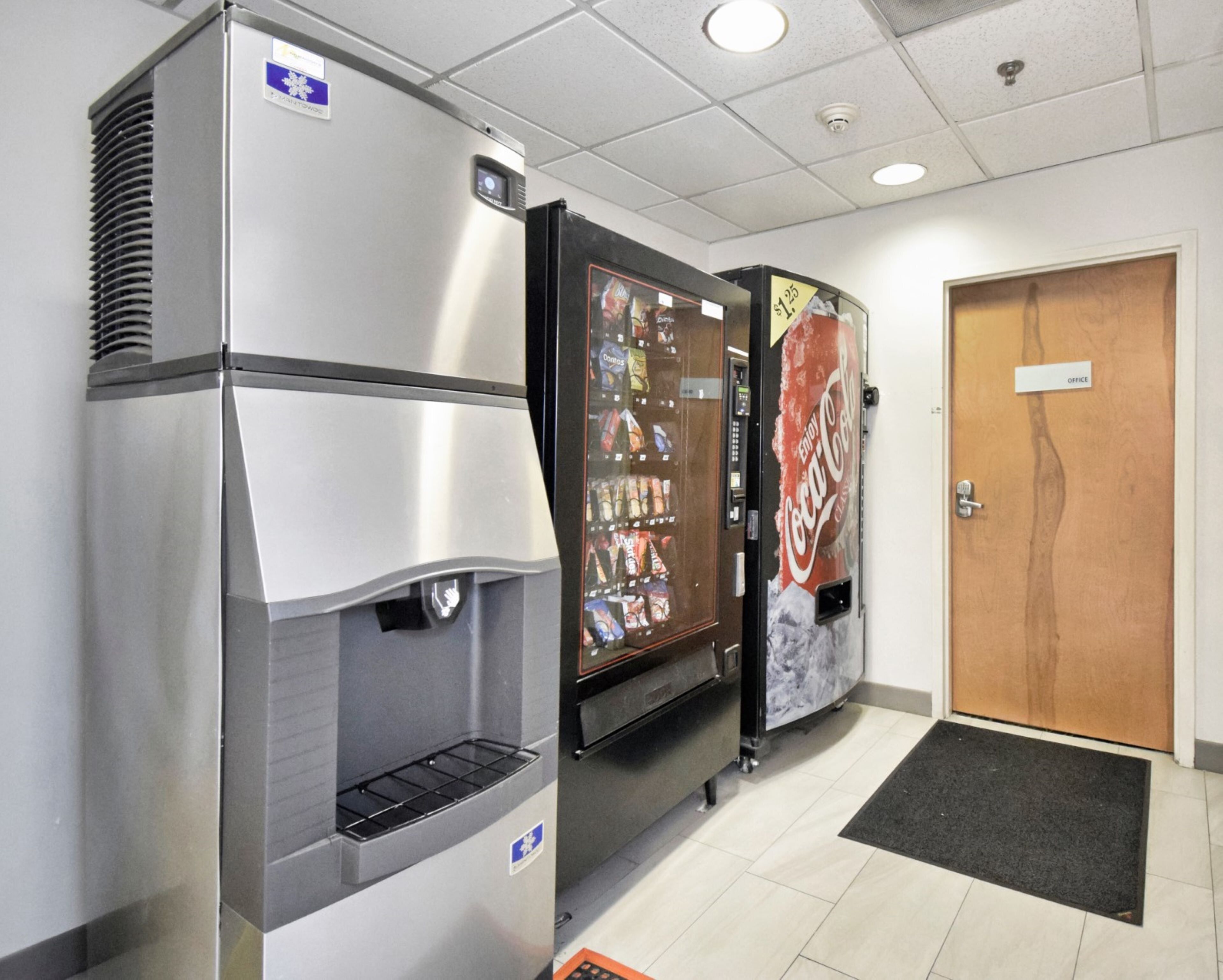 A vending machine area with a Coca-Cola dispenser and a water dispenser.