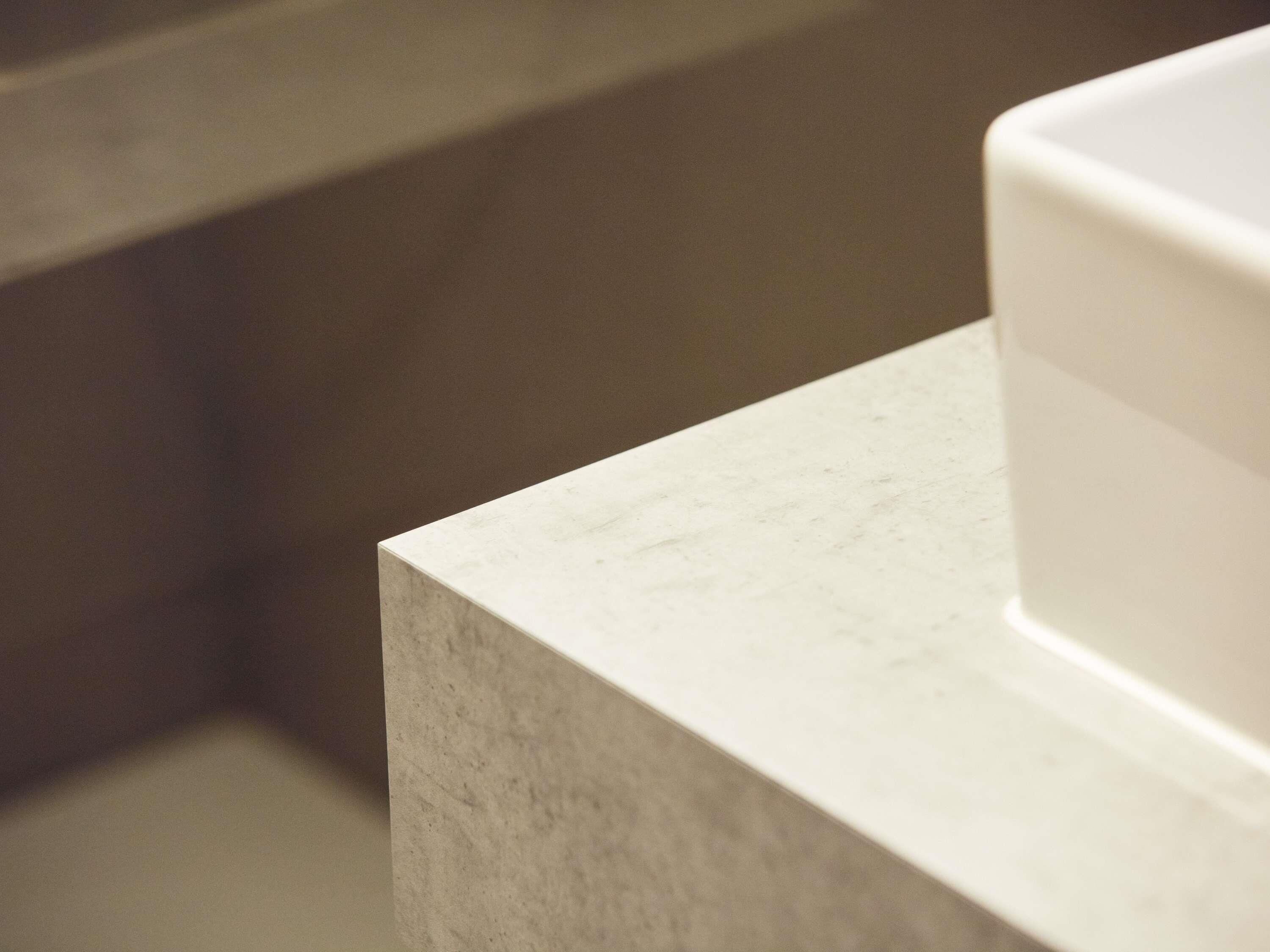 Une salle de bain avec un comptoir blanc et un lavabo blanc.