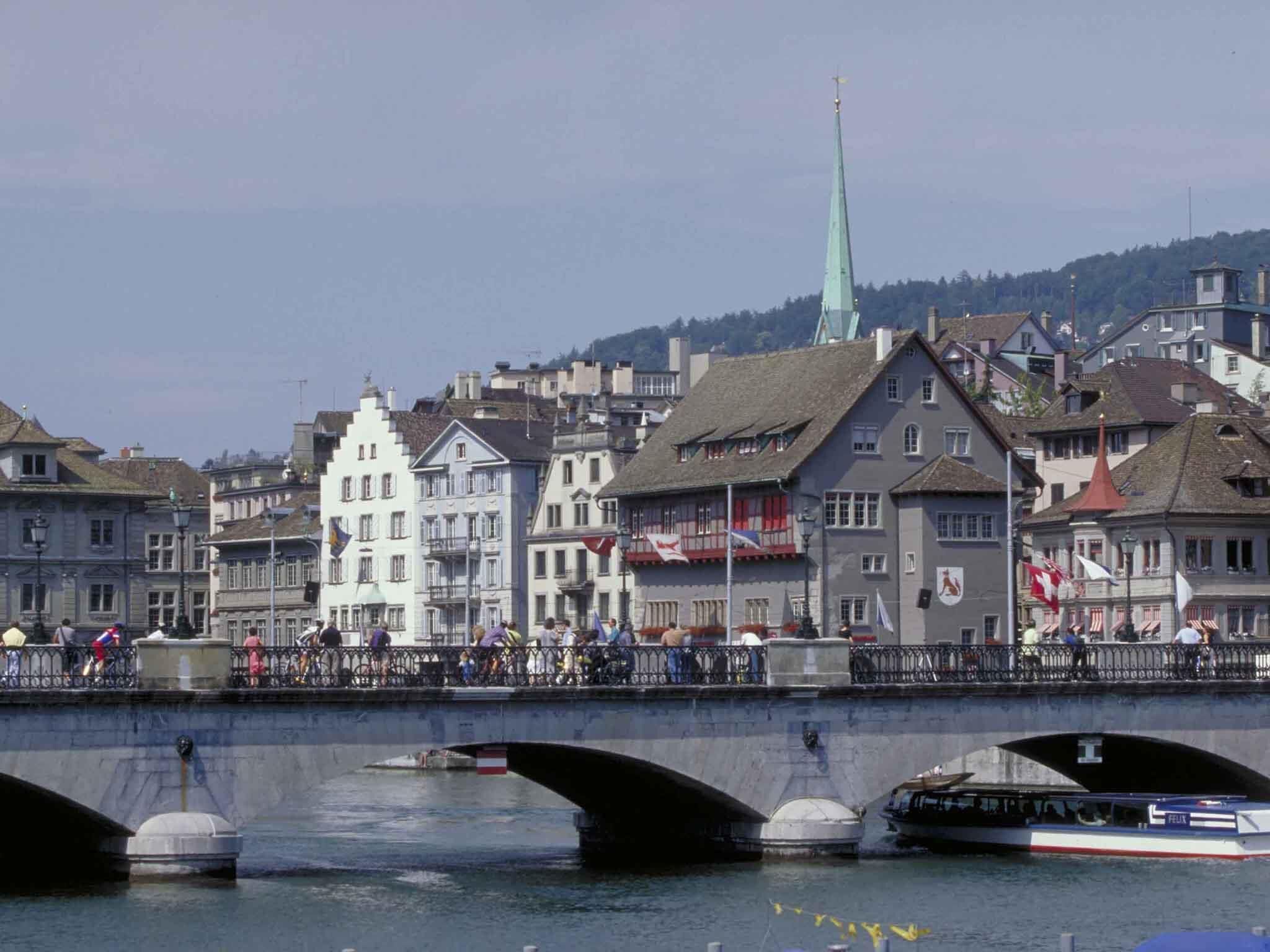 A bridge with multiple arches over a river, surrounded by historic buildings with varied architecture.