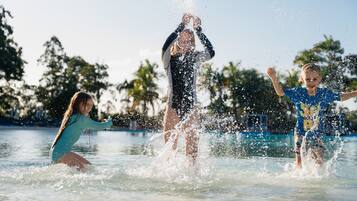 Guests can enjoy lively water play at the outdoor pool surrounded by lush greenery.