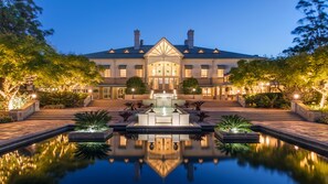 A large, well-lit building with a symmetrical facade, a central fountain, and a reflecting pool. - InterContinental Sanctuary Cove Resort by IHG (Hope Island)