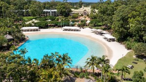 A resort with a large pool, beachfront seating, and lush greenery. - InterContinental Sanctuary Cove Resort by IHG (Hope Island)