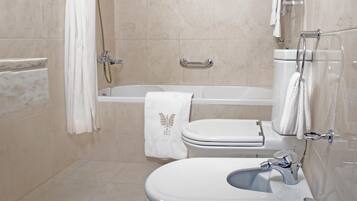 A modern bathroom with a bathtub, toilet, and sink.