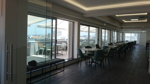 Un comedor moderno con ventanas amplias, un balcón y vistas a la ciudad.