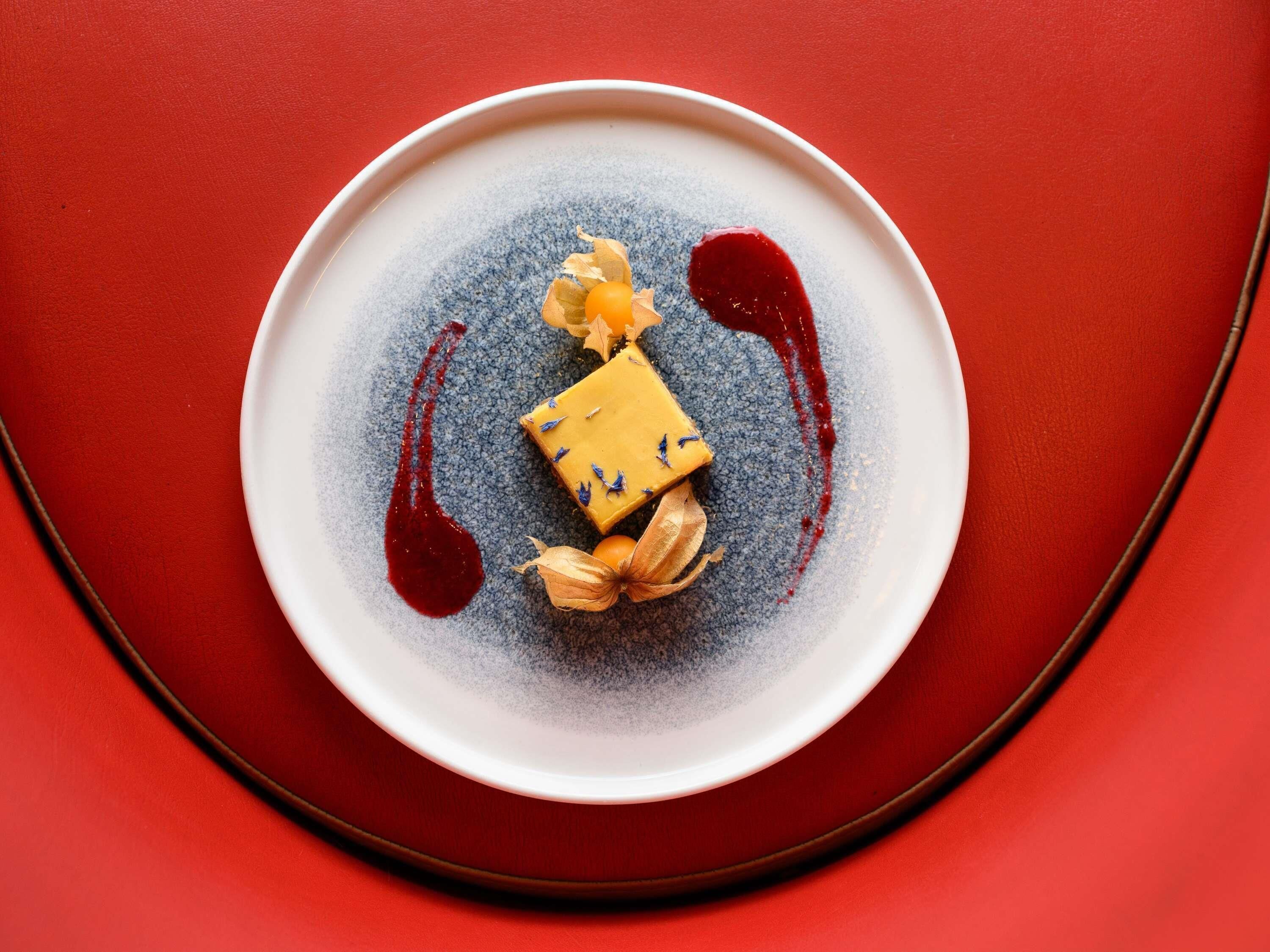 A dessert on a plate with a red background.