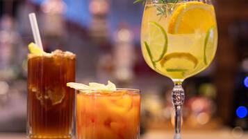 Tres vasos de bebidas sobre una barra.