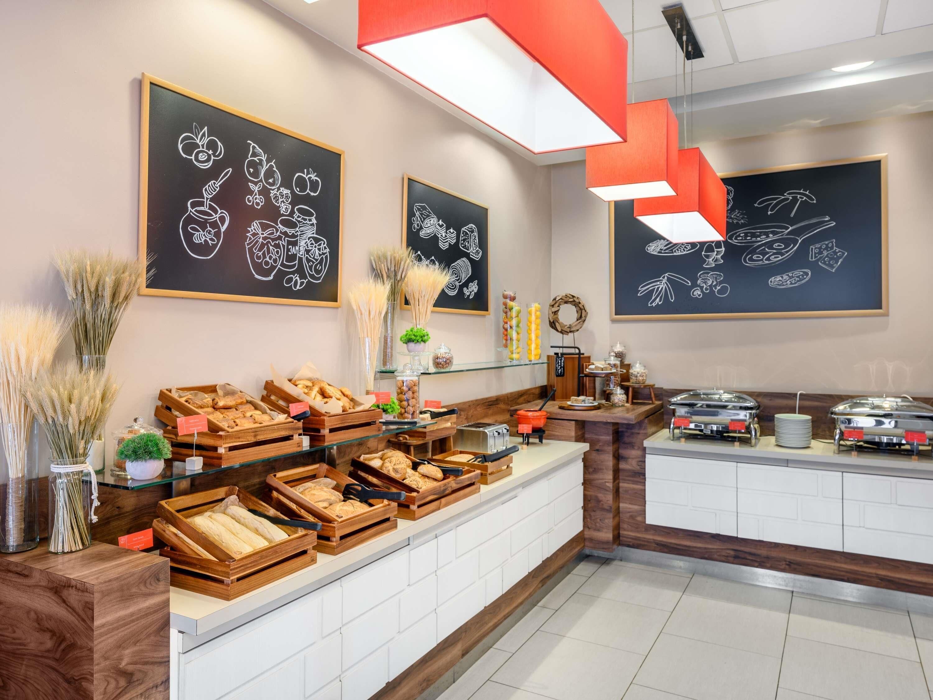 A breakfast buffet with wooden serving trays, a coffee station, and chalkboard decorations on the wall.