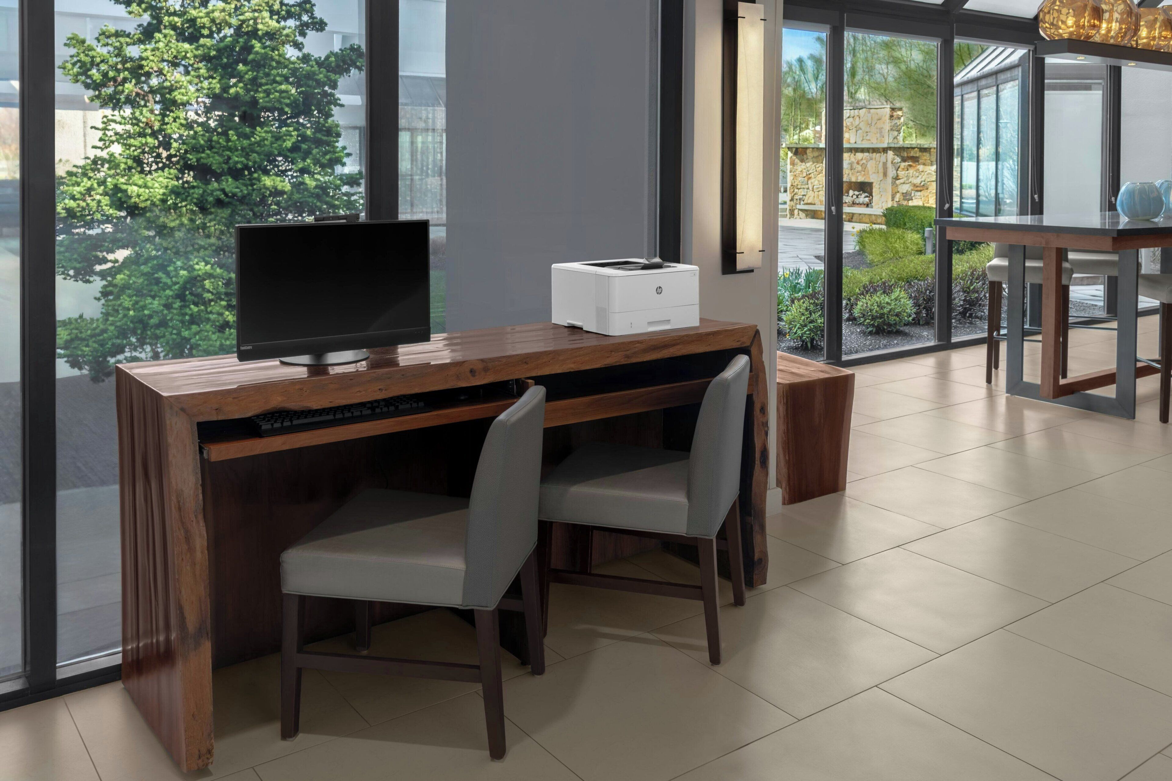 Un espacio de oficina moderno con un escritorio de madera, un monitor de computadora e impresora.