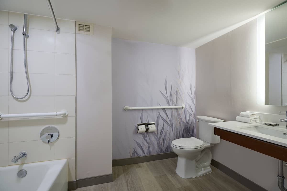 A modern bathroom with a shower, toilet, and bathtub.