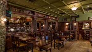 A bar with wooden furniture, a brick wall, and a green ceiling. - Hanover Marriott (Whippany)