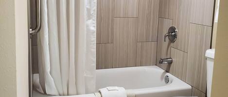 Ein modernes Badezimmer mit Dusche, Badewanne und Toilette.