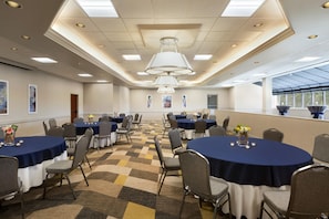 A conference room with round tables, chairs, and a patterned carpet. - Hilton Fort Collins (Fort Collins)