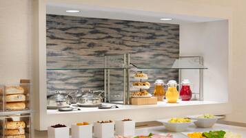 A buffet setup with various food items and beverages.