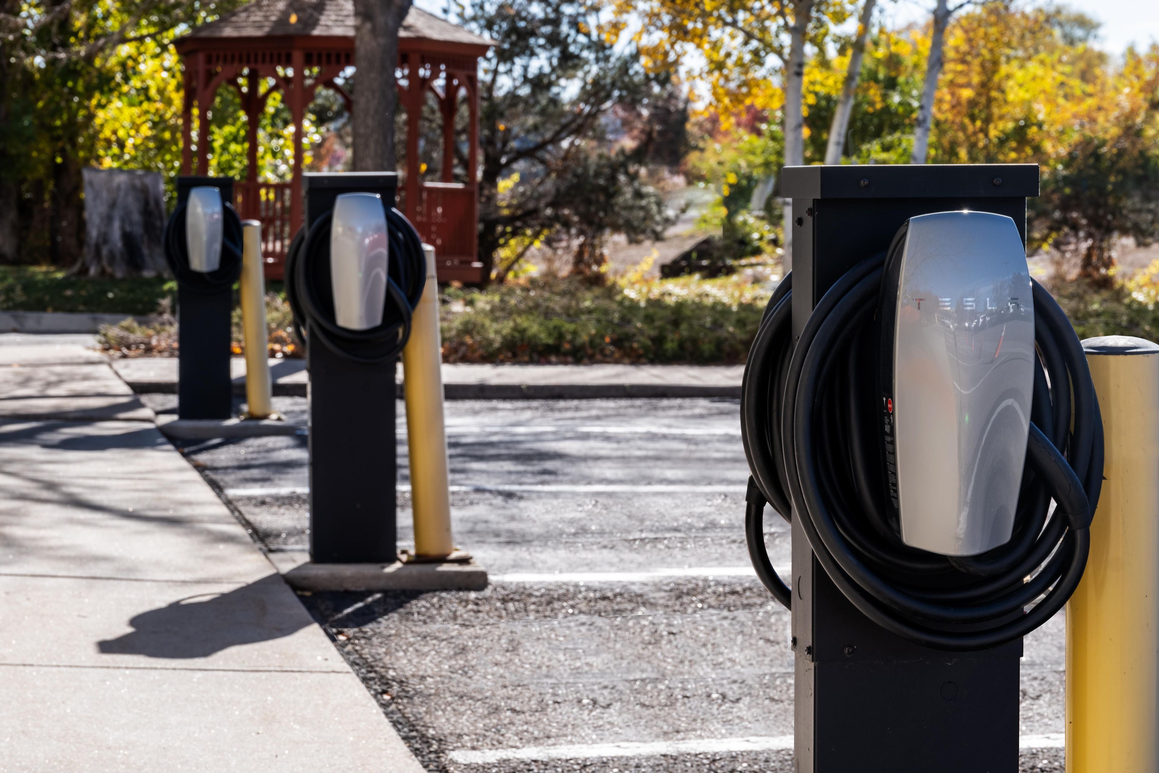Electric vehicle charging stations with a gazebo in the background.