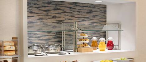 A buffet setup with various food items and beverages.