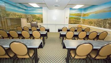 Un salón de conferencias con mesas y sillas dispuestas para una reunión.