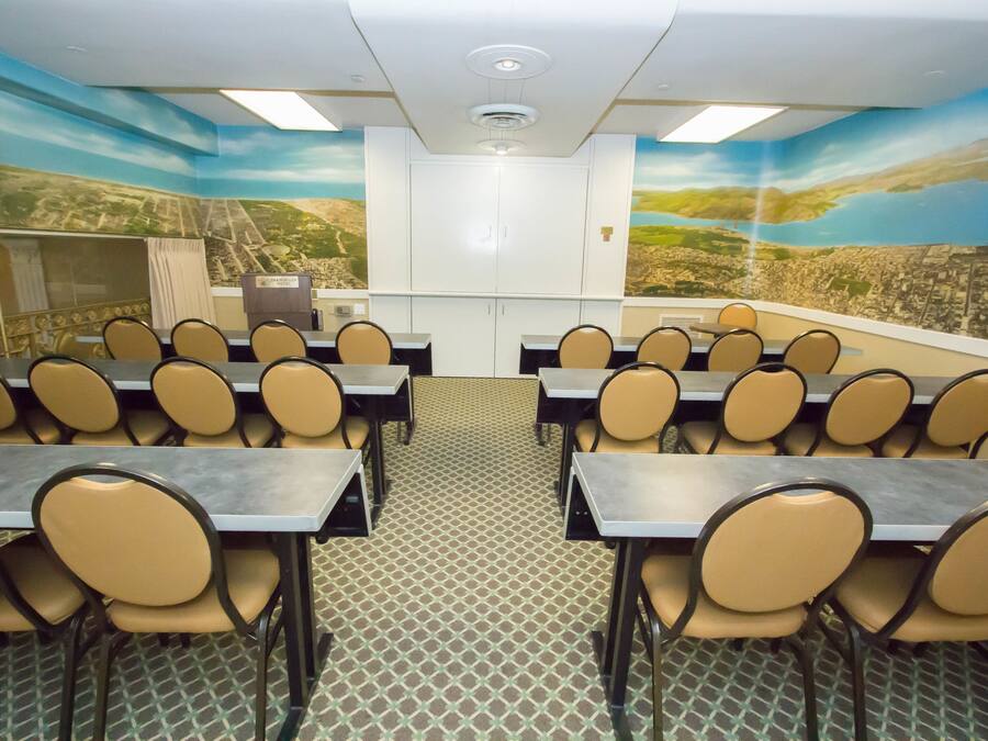 Un salón de conferencias con mesas y sillas dispuestas para una reunión.