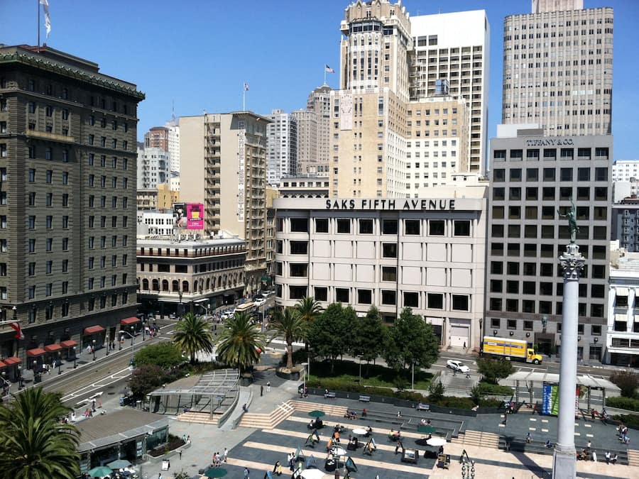 Saks Fifth Avenue-byggnaden med sin moderna fasad, omgiven av andra höga byggnader.