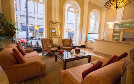 A lobby with seating, a reception desk, and large windows.