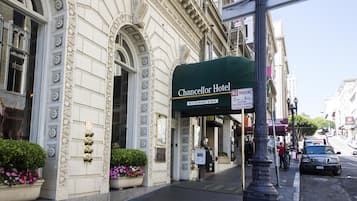 The exterior of the Chancellor Hotel with a green awning, a 'No Parking' sign, and a 'Restaurant & Bar' sign.