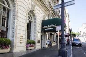 The exterior of the Chancellor Hotel with a green awning, a 'No Parking' sign, and a 'Restaurant & Bar' sign.
