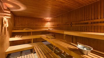 Eine Holzsauna mit Bänken und einem Eimer.