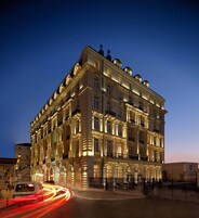 A multi-story hotel with classical architecture, featuring balconies and ornate detailing.
