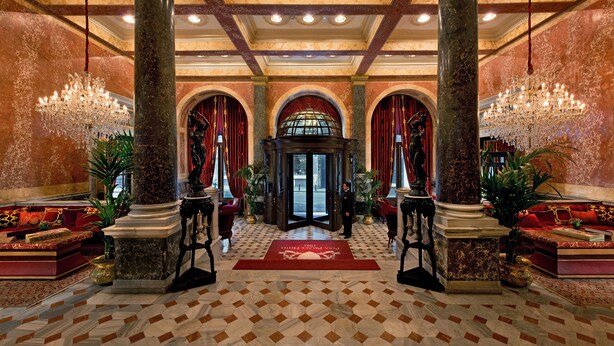 A grand lobby with marble columns, red velvet curtains, and ornate chandeliers. - Pera Palace Hotel (Istanbul)
