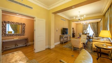 A spacious living room with a large mirror, a television, and elegant furniture.