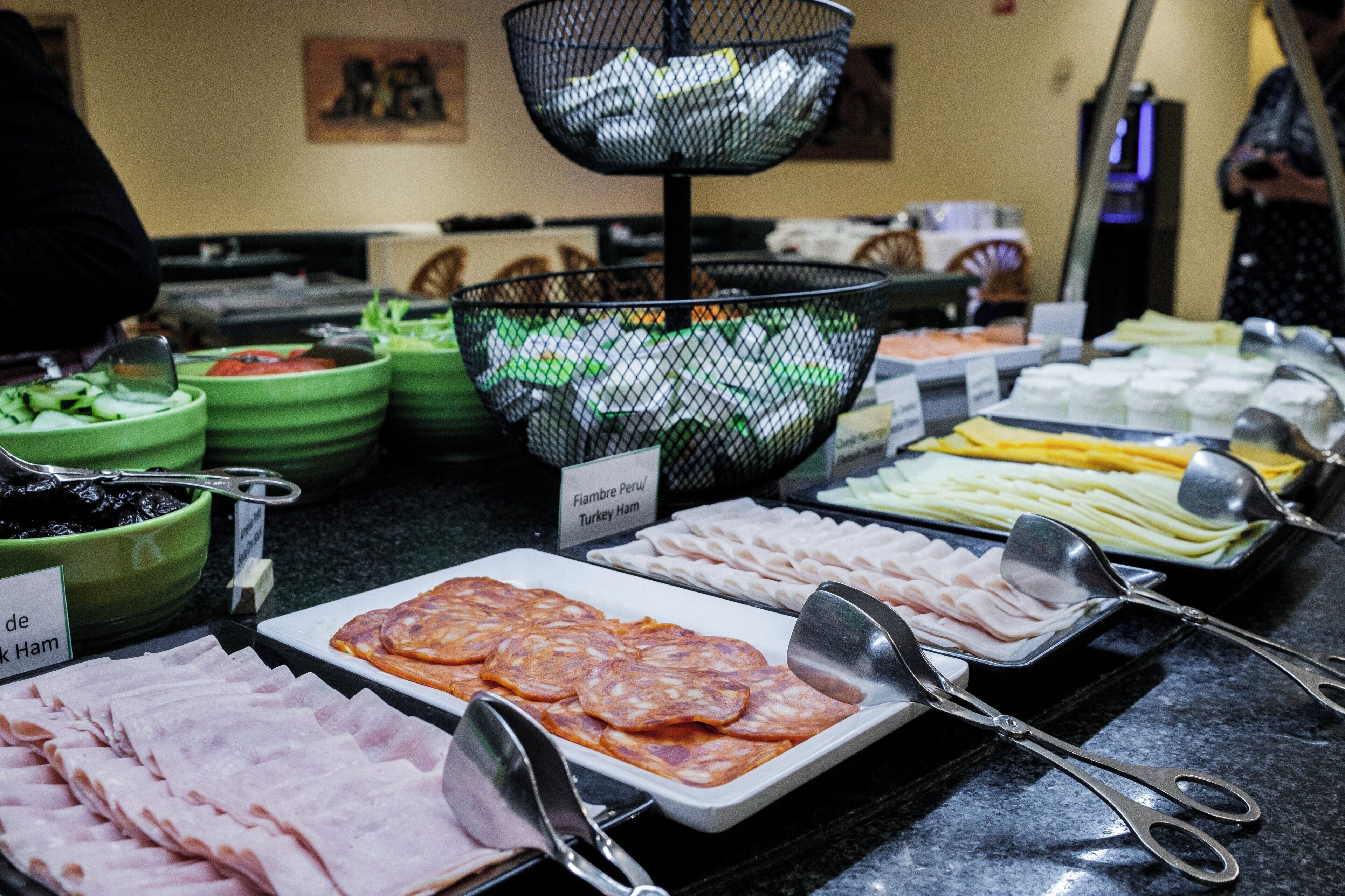Ein Buffet mit verschiedenen Speisen, darunter Schinken, Pute und Käse.