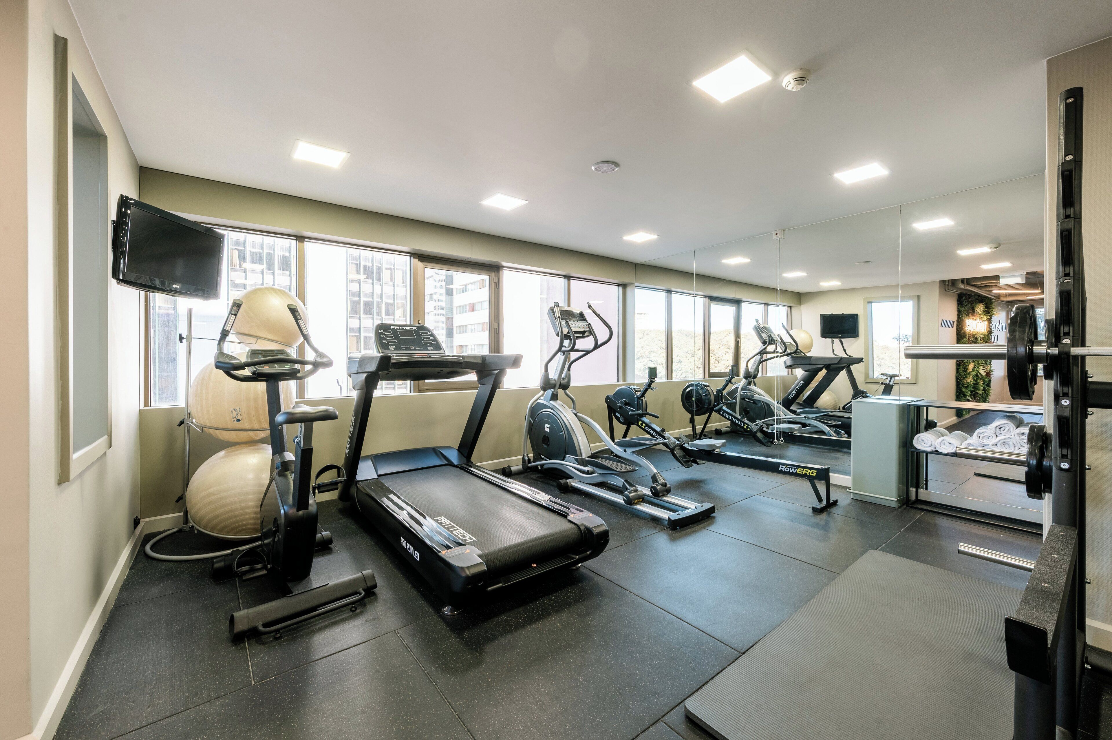 A gym with treadmills, elliptical machines, and a rowing machine.