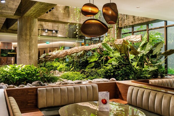 A modern interior with a seating area, a large window, and a hanging plant. - Holiday Inn Lisbon Continental by IHG (Lisbon)