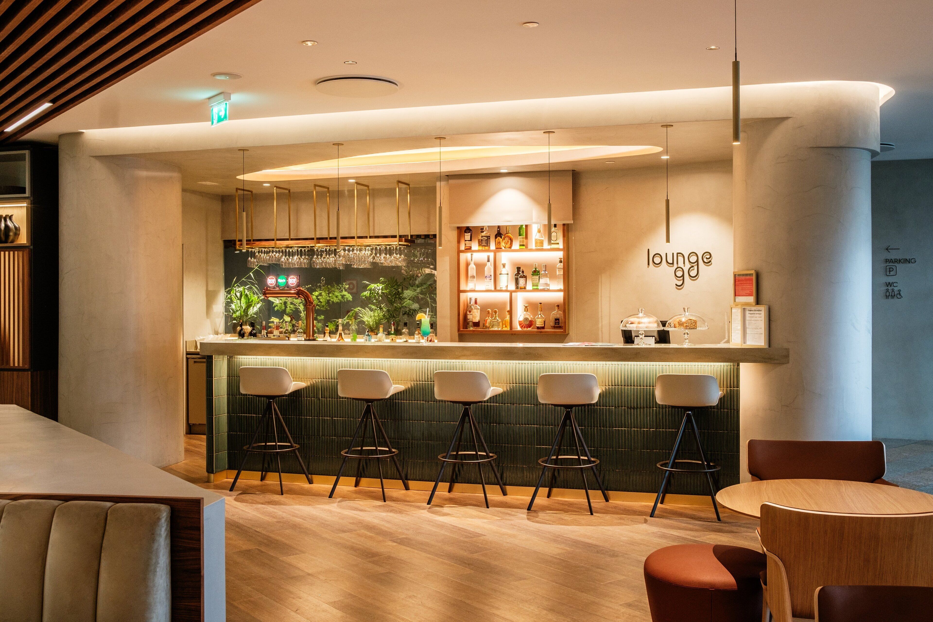 A modern lounge area with a bar, seating, and a sign reading "lounge 90".