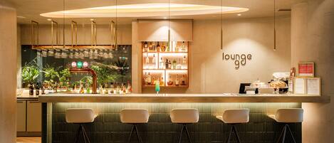 A bar area with a counter, bar stools, and shelves of bottles.