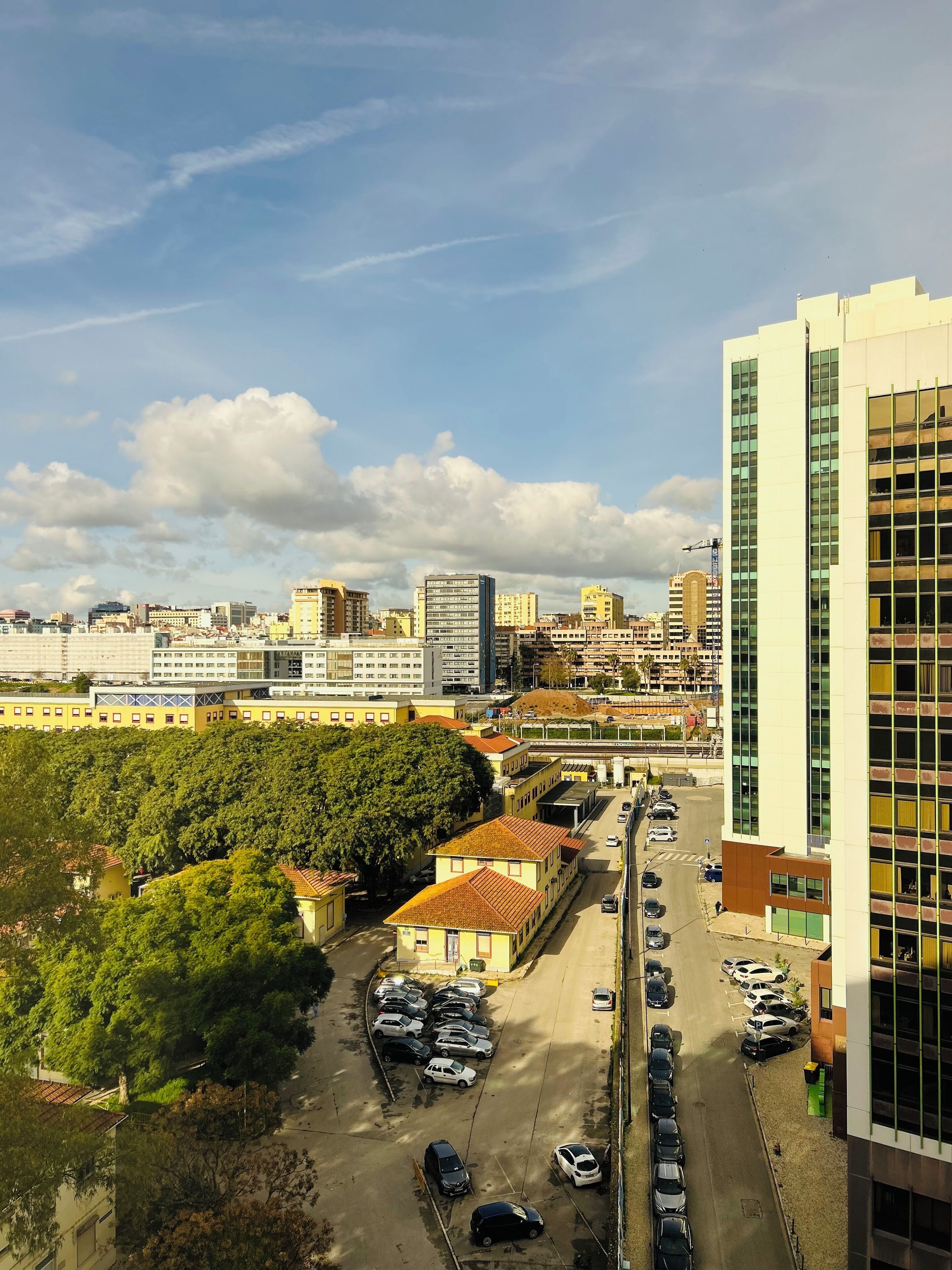 Une vue urbaine comprenant un parking et des immeubles.
