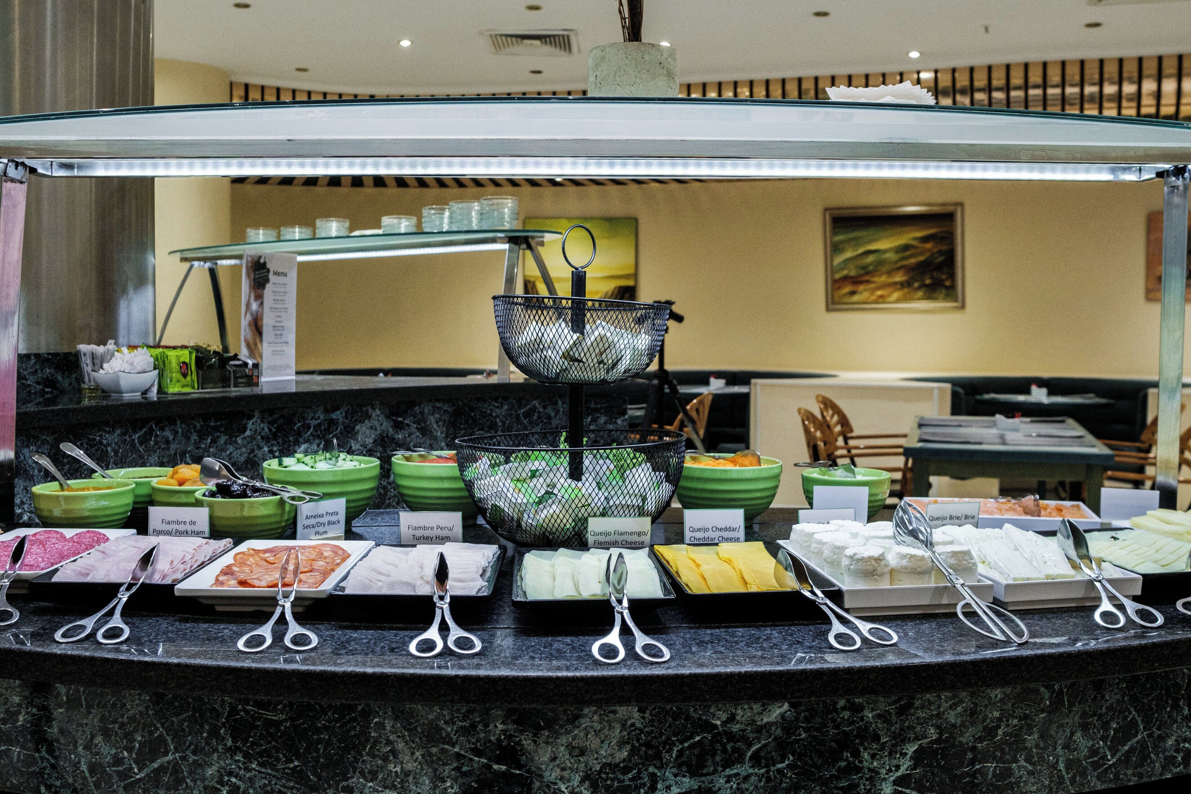A buffet counter with various food items and utensils.