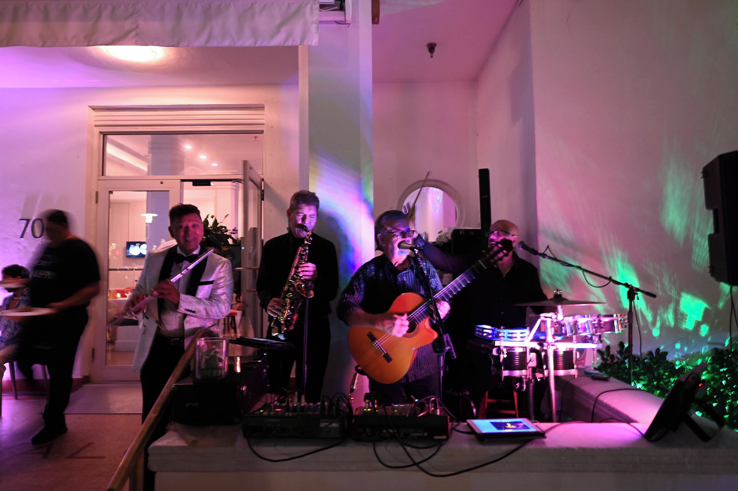 A band performing on a stage with musical instruments and a drum set.