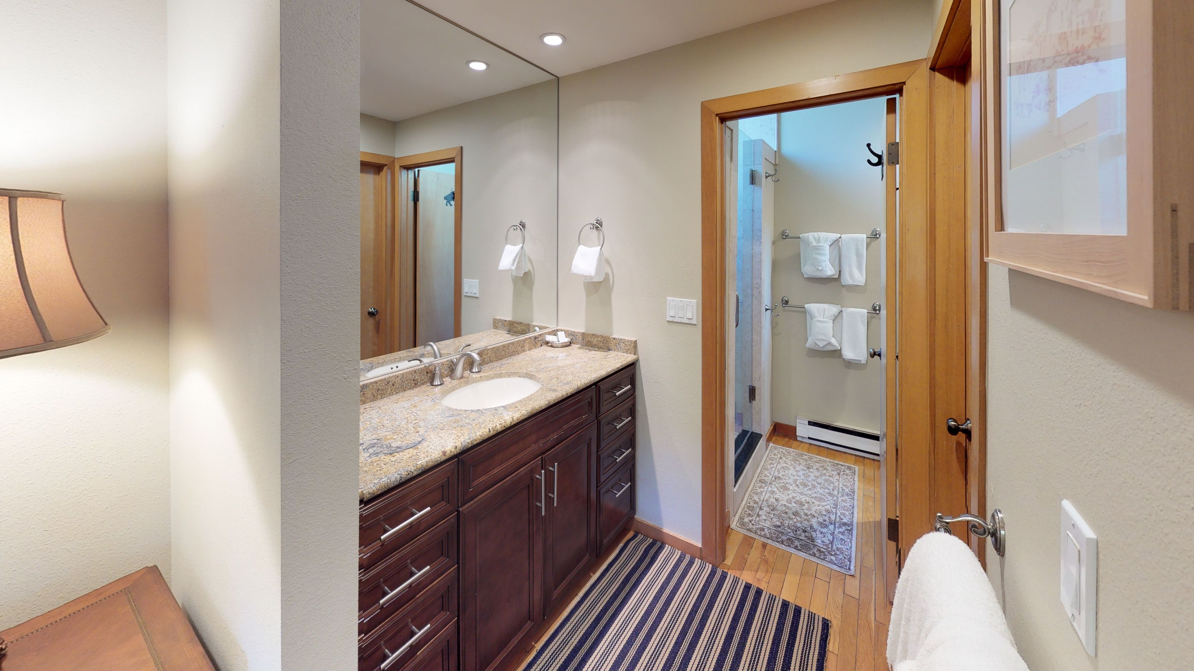A modern bathroom with a double sink, vanity, and a walk-in shower.