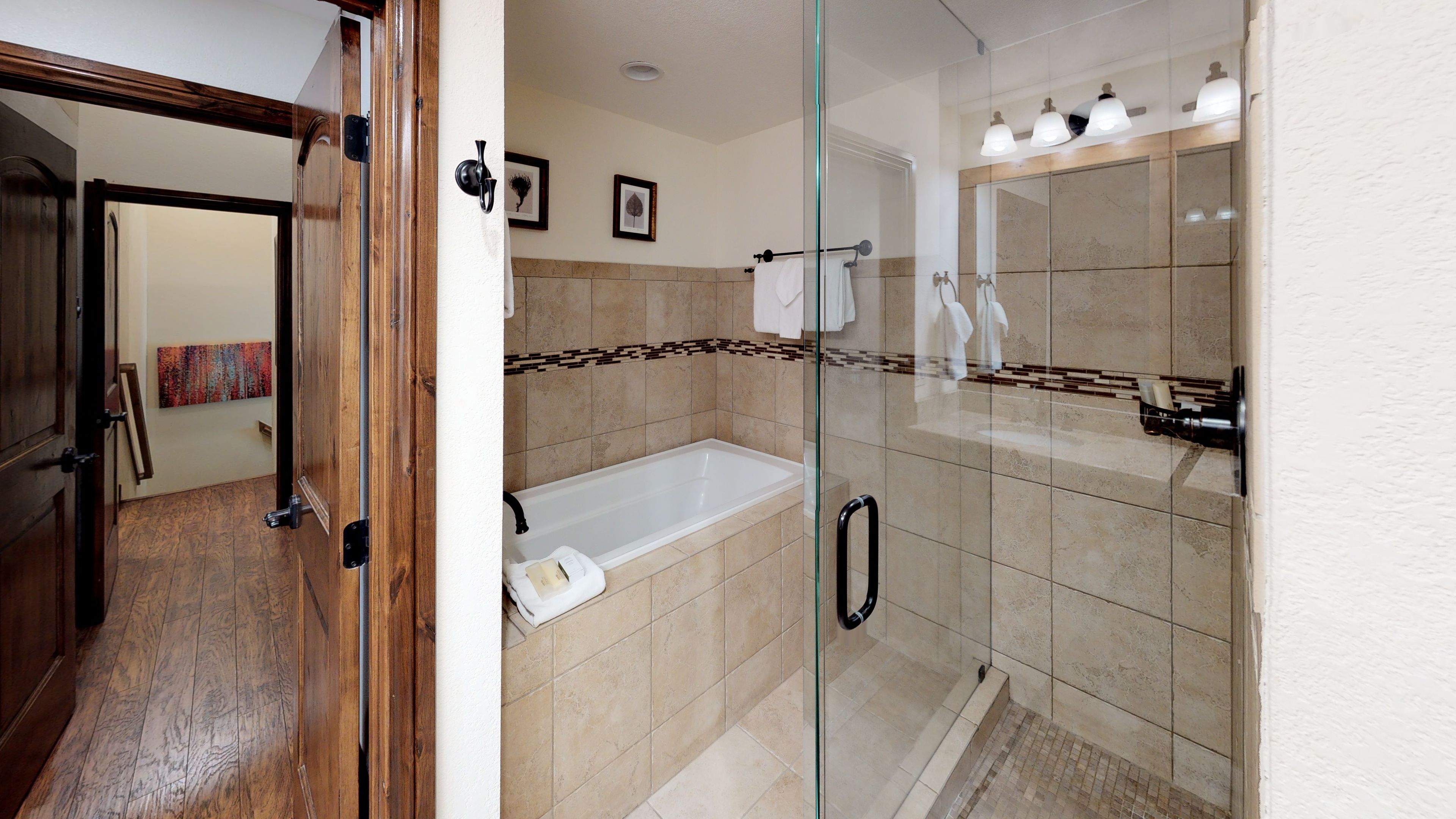 Un baño moderno con cabina de ducha de vidrio, bañera y retrete.